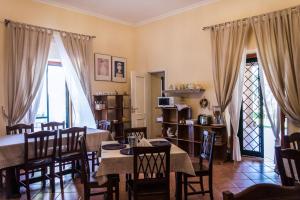 a dining room with tables and chairs and windows at La Masseria in Capua