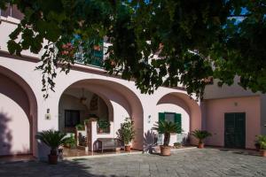 un patio de un edificio con arcos y macetas en La Masseria, en Capua