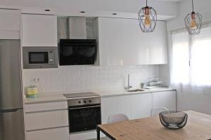 a kitchen with white appliances and a wooden table at G&D Vivienda Turística in Logroño