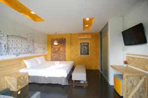 um quarto com uma cama e uma televisão de ecrã plano em SHA The Regent Resort Phuket Kamala Beach em Praia de Kamala