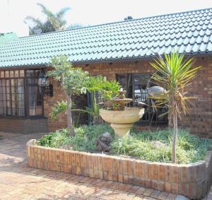a garden in front of a brick building with plants at House on York in Johannesburg