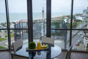 a dining room with a table and a view of the ocean at Apartment Natalia Sea Towers in Batumi