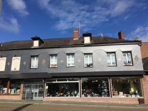sklep przed ceglanym budynkiem z oknami w obiekcie gite du moulin w mieście Aumale