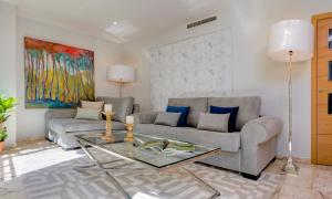 uma sala de estar com um sofá e uma mesa em Genteel Home Vinuesa em Sevilha