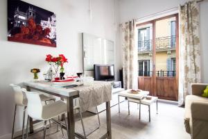 sala de estar con mesa, sillas y sofá en Loft las letras, en Madrid