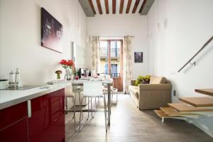 cocina y sala de estar con mesa y sofá en Loft las letras, en Madrid