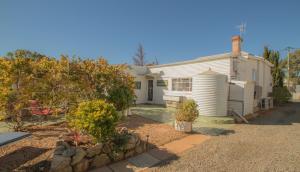een wit huis met een tuin ervoor bij Ella's Place in Broken Hill