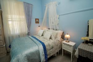 a blue bedroom with a bed and a table with a lamp at Ella's Place in Broken Hill