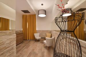 a room with a table and chairs and a vase with flowers at Veneto Suite Rome in Rome