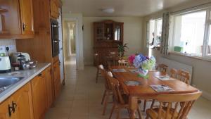 a kitchen with a wooden table and a dining room at Ocean View in Glandore