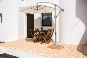 a table and chairs under an umbrella on a patio at Casa Maui in La Oliva