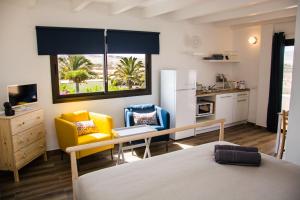 Un dormitorio con una cama y un escritorio y una cocina. en Casa Maui, en La Oliva