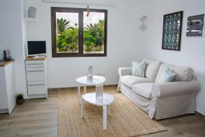 una sala de estar con un sofá y una mesa en Casa Maui, en La Oliva