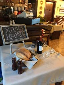 a table with a sign and a loaf of bread on it at Petropanagia in Elatochori