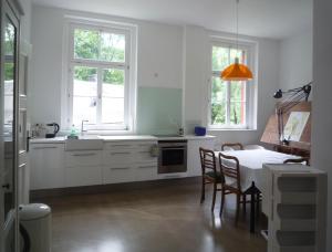 a kitchen with white cabinets and a table with chairs at Postamt Lauenstein in Lauenstein