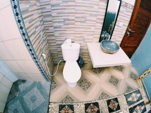 a bathroom with a toilet and a table at Pandawa Lembongan Homestay in Nusa Lembongan