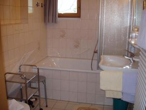 a bathroom with a tub and a sink at Gästehaus zur Färbe Apartments in Oberstdorf