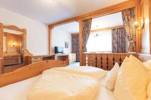 a bedroom with two beds and a large window at Bergidyll & Hotel Trofana in Leutasch