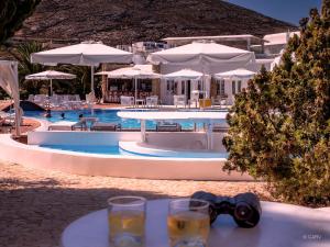 a table with glasses and a bow tie next to a pool at Chora Resort Hotel & Spa in Chora Folegandros