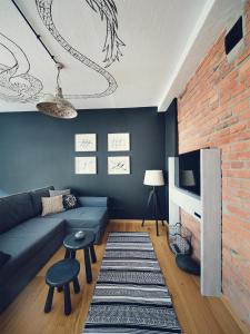 a living room with a blue couch and a brick wall at Habitat Apartments in Kraków