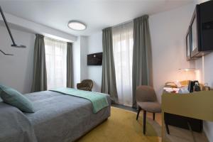 una camera d'albergo con letto, scrivania e finestra di Villaggio Narrante - Le Case dei Conti Mirafiore a Serralunga d'Alba