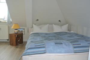 a bedroom with a large bed with a blue comforter at Hotel Rosenhof in Kühlungsborn
