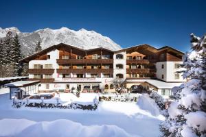 un hotel nella neve di fronte a una montagna di Bergidyll & Hotel Trofana a Leutasch