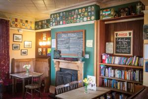 een restaurant met een open haard en een boekenplank met boeken bij Cumberland Inn in Alston