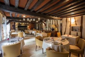 a restaurant with white tables and yellow chairs at Le Petit Coq aux Champs - Teritoria in Campigny