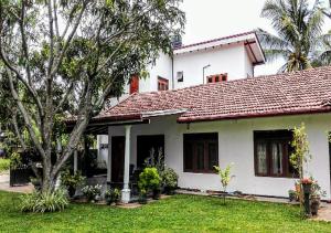 uma casa branca com um telhado vermelho em House of Seya em Negombo