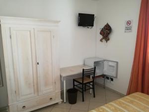 1 dormitorio con escritorio, mesa y TV en B&B Angel's Dream, en Porto Fuori
