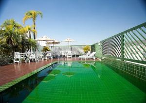 a green and white pool with a green lawn chair at Dayrell Hotel e Centro De Convenções in Belo Horizonte