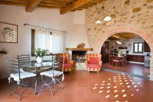 サン・カシャーノ・イン・ヴァル・ディ・ペーザにあるI Greppi di Silliのリビングルーム(テーブル、椅子、暖炉付)
