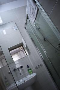 Un baño con lavabo, ducha y espejo. en Villa Romeo, en Brzeg 32 fotos más