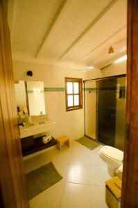 a bathroom with a shower and a toilet and a sink at Na Villa dos Algodões in Marau