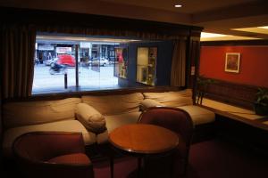 un soggiorno con un divano, un tavolo e delle sedie di Torre Obelisco a Buenos Aires