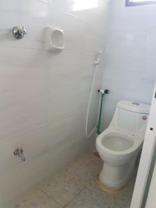 a white bathroom with a toilet and a shower at Golden Guest House- Miritini in Mombasa +24 photos