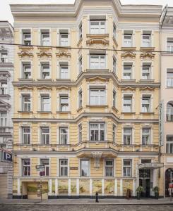 ein großes gelbes Gebäude in einer Stadtstraße in der Unterkunft Hotel Rathaus - Wein & Design in Wien