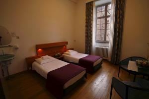 a hotel room with two beds and a sink and a window at Abdij Hotel Rolduc in Kerkrade +37 photos
