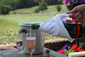a person pouring a bottle of wine into a glass at London Beach Country Hotel & Golf Club in Tenterden
