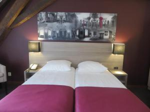 a bedroom with two beds and a picture of houses at Abdij Hotel Rolduc in Kerkrade