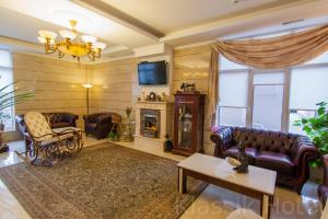 a living room with leather furniture and a fireplace at Klassik Hotel in Chişinău