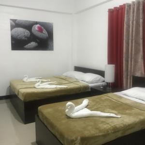 twee bedden met mensen in een kamer bij 4C's Tourist Lodge in Puerto Princesa City