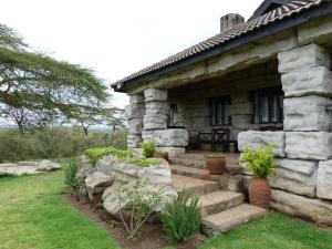 a stone house with stairs in front of it at Shwari Cottages in Naivasha