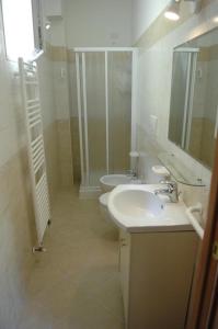 uma casa de banho com um lavatório, um WC e um espelho. em Residence Meeting em Gabicce Mare