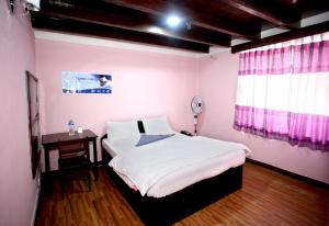 una camera da letto con un letto, un tavolo e una finestra di Mitra Garden Inn a Kathmandu