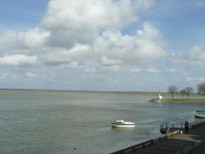 un petit bateau dans l'eau à côté d'un quai dans l'établissement Regard Sur La Baie, à Saint-Valery-sur-Somme