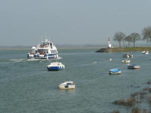 un grand bateau dans une grande étendue d'eau avec des bateaux dans l'établissement Regard Sur La Baie, à Saint-Valery-sur-Somme