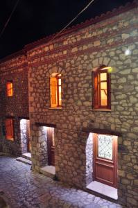 a stone building with doors and windows at night at Limni Stone Apartments in Límni