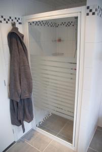 a shower with a glass door in a bathroom at Bed and Breakfast de Verwennerij in Ermelo